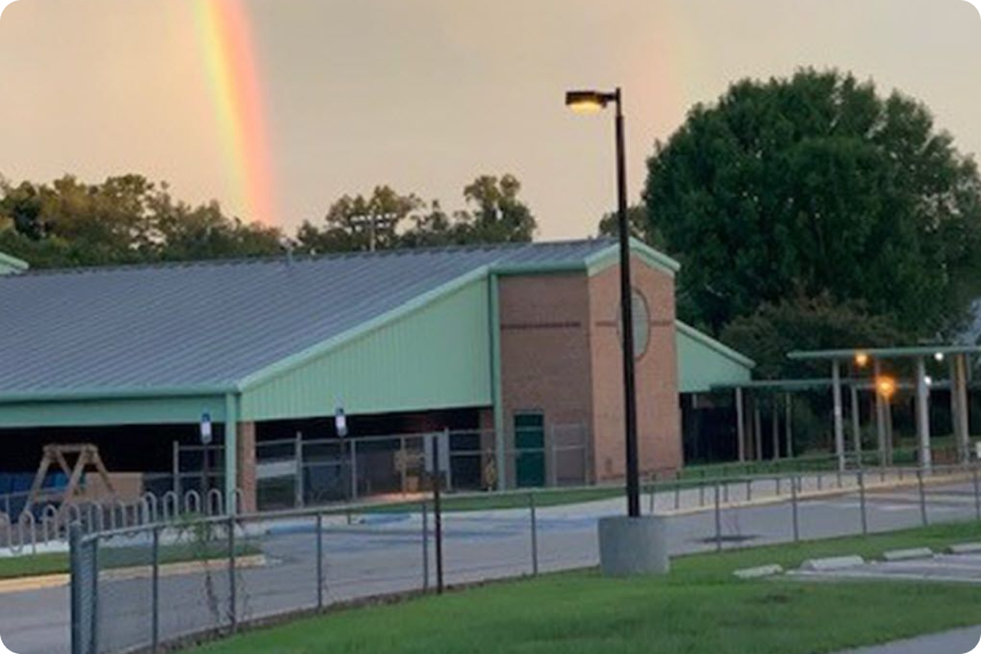 building with rainbow behind it
